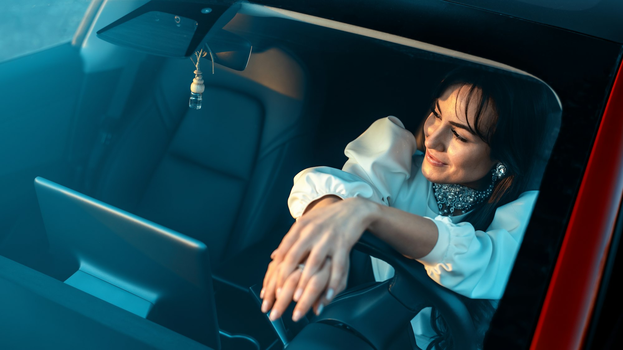 Woman posing inside a red car